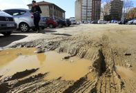 Grandes socavones convierten en un lodazal el acceso al aparcamiento. 