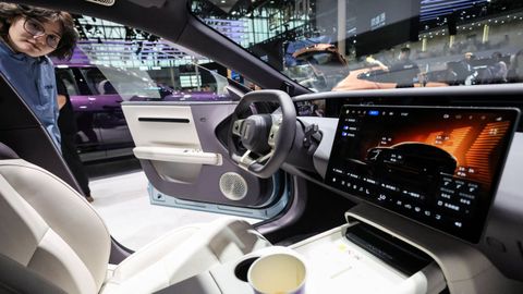 Una mujer observa la pantalla de navegaci�n y el interior de un coche el�ctrico presentado en abril en la Exposici�n Internacional del Autom�vil de Pek�n.