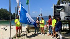 Izado de la bandera azul en la playa de Mogor, en Mar�n