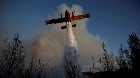 Un avi�n apaga fuegos apaga un incendio forestal cerca de la aldea de Metochi, al norte de Atenas