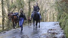 Carmen, a lomos de La, con las alforjas llenas de botellines de agua, por la carretera anegada