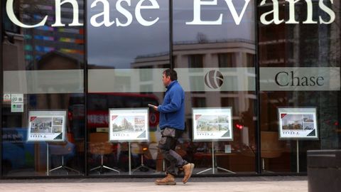 Un viandante camina ante el escaparate de una agencia inmobiliaria en Londres.