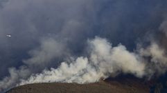 Un helic�ptero se dispone a arrojar agua en el incendio, que avanz� hacia el sur empujada por el viento