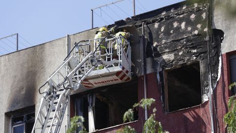Los bomberos revisan la estructura del edificio afectado por el fuego en su quinto piso