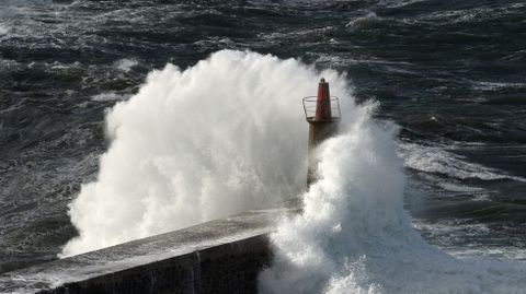 Una ola envuelve el faro de Viavelez