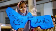 Una ni�a iran� sostiene un cartel que representa el estrecho de Ormuz