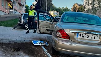 Un agente de la Guardia Civil delante del coche que conduc�a el conductor temerario en Oleiros