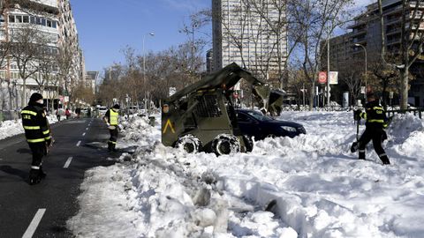 Una excavadora militar y varios operarios retiran la nieve en el Ministerio de Defensa, en el madrile�o Paseo de la Castellana