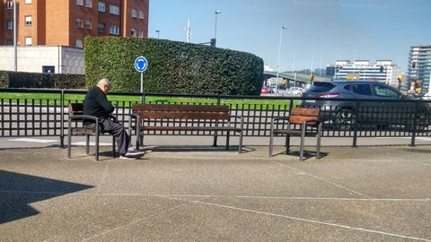 Una persona mayor dormita en un parque del centro de Gijn