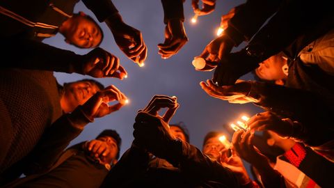 Un grupo de nepal�es encienden velas en homenaje a las v�ctimas del avi�n accidentado en Kadmand�