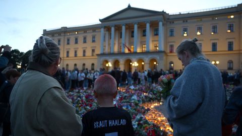 Un ni�o con la camiseta de Haaland, ante el altar improvisado en honor al rey Harald de Noruega
