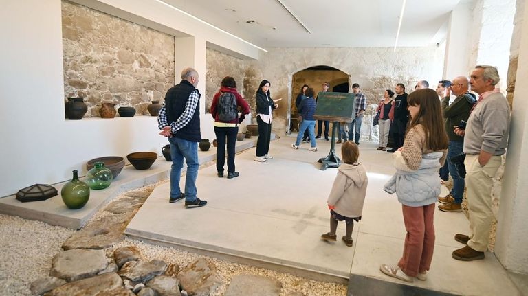 Un grupo de visitantes en la antigua bodega del monasterio, donde se exponen objetos de uso cotidiano
