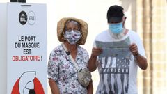 Personas usando mascarillas junto a un aviso que indica la obligatoriedad de las mismas en Bruselas, B�lgica.