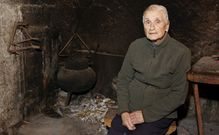 Aos seus 85 anos, Dolores Mac�as -na lareira da s�a casa-, sempre ten unha copla nos beizos. 