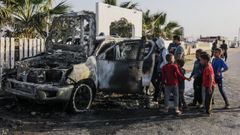 Unos ni�os observan el veh�culo en el que viajaban los cooperantes asesinados en un ataque israel� en Gaza