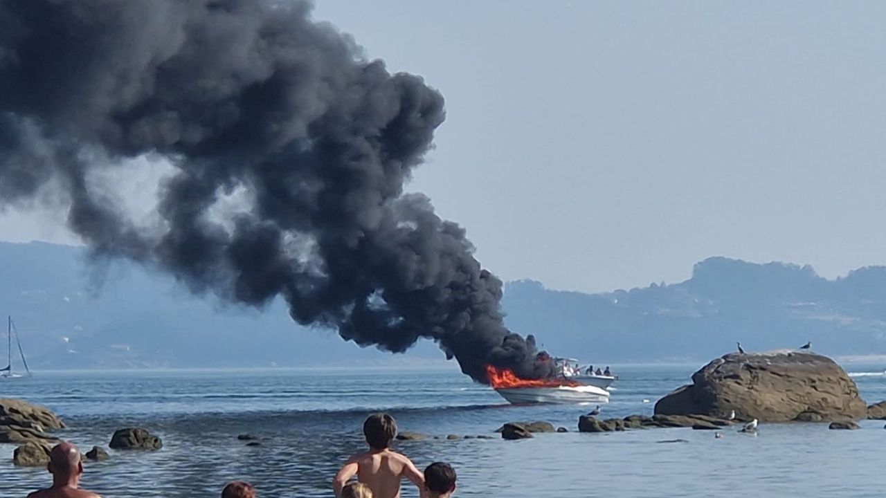 Arde una lancha fondeada en el mar frente a la playa de A Carabuxeira, en Sanxenxo