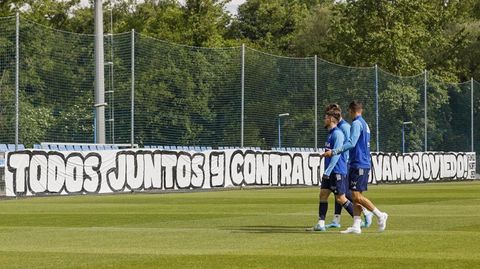 Los jugadores del Oviedo pasan por delante de la pancarta