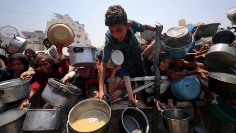 Varias personas esperan para recibir comida en la Ciudad de Gaza.