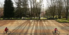 Imaxe duns ciclistas paseando pola explanada onde se sit�an as casetas do polbo durante o San Froil�n. 