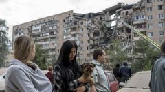 Un grupo de mujeres junto a un edificio destruido por los bombardeos sobre Kiev. 