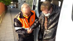 Un voluntario de Protecci�n Civil ayuda a una vecina de A R�a a bajar de la furgoneta en uno de los traslados