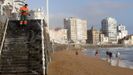 Un operario limpia una de las escaleras de acceso a la playa de San Lorenzo de Gij�n