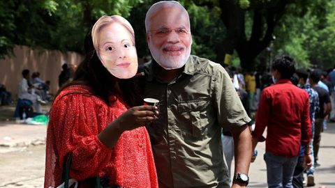 Simpatizantes del Partido de las Cucarachas con caretas del primer ministro Modi y la italiana Meloni