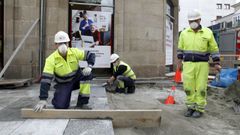 Unos operarios, trabajando con mascarilla