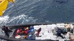 Los cuatro tripulantes, en la proa, con las manos esposadas. Tres de ellos tumbados, y el cuarto sentado. La narcolancha, que fue intervenida a 500 millas de Canarias a mediados de esta semana, muestra c�mo los narcotraficantes suelen ocupar pr�cticamente toda la superficie de la embarcaci�n para transportar la droga y los bidones de combustible para realizar largos desplazamientos. Como se ve en la imagen, apenas queda sitio para los tripulantes, que aparecen ya detenidos y esposados en un peque�o espacio de la proa; mientras, los agentes revisan el material incautado en la operaci�n.