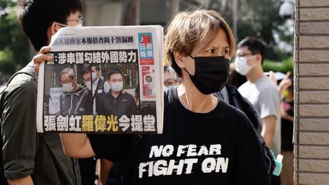 Una manifestante protesta con un ejemplar del �Apple Daily� ante el tribunal que ley� los cargos a los directivos del diario detenidos.