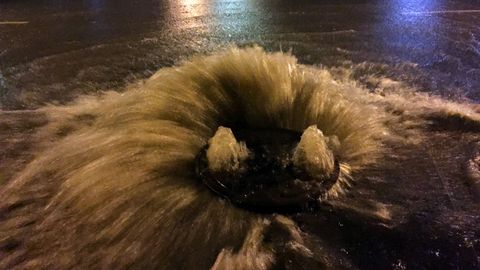 Tapa de alcantarilla rebosando frente a la entrada de la colonia El Pisón