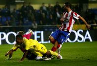 El villarrealense Uche, entre los rojiblancos David de Coz y el meta Yoel, en el duelo de El Madrigal.