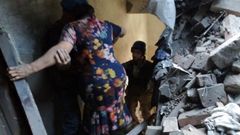 Personal de emergencia ayuda a una mujer a salir de un edificio convertido en escombros en la localidad de Toretsk, en la provincia de Donetsk