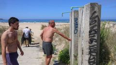 Ba�istas comprobando que no hay agua en las duchas de la playa de A Frouxeira. 