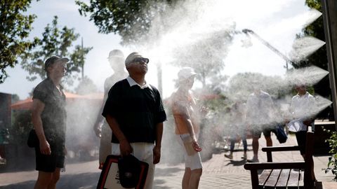Varios espectadores se refrescan con nebulizadores de agua durante el Roland Garros, Par�s (Francia).