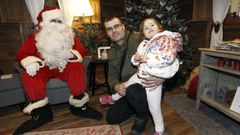 Imagen de archivo de una familia visitando a Papá Noel en su caseta