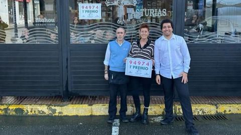 Amalia Gil, propietaria del bar Asturias, en el centro, con uno de los premios de lotería que ha dado