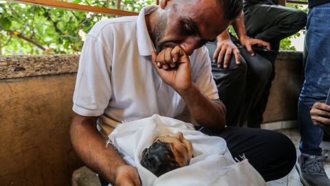 Un padre mira a su hija de cinco meses, fallecida en el sur de Gaza tras sufrir desnutrición severa por el bloqueo israelí
