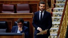 Casado pasa por junto del ministro de Sanidad al disponerse a tomar la palabra en el pleno del Congreso