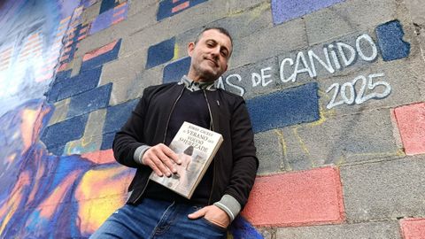 Jordi Cicely posa con su nuevo libro en uno de los murales de las Meninas de Canido, en Ferrol. 