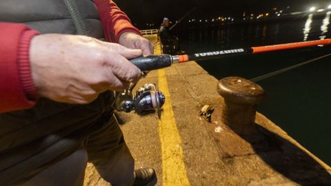 Un pescador disfruta de su afici�n en el puerto de Laxe.