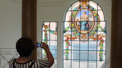 Una visitante fotograf�a la vidriera de la fachada principal