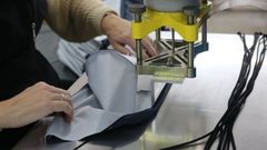 Trabajadora confeccionando una prenda de vestir en una empresa gallega