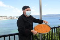 El chef muestra una de sus especialidades en la terraza del hotel, con Silgar al fondo
