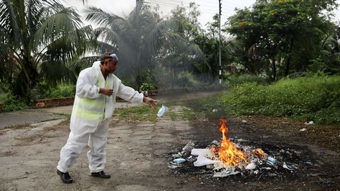 En Daca, la capital de Bangladesh, un trabajador quema su traje de proteccin tras asistir al entierro de un fallecido por coronavirus