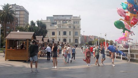 Personas paseando en la trigsima Fiesta de la Sidra Natural de Gijn ha comenzado este sbado con 22 participantes en un mercadillo de productos artesanos derivados de la manzana y se desarrollar hasta el prximo 29 de agosto