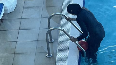 Una mujer vestida con un burkini sale de una piscina p�blica.