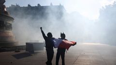 Dos encapuchados sostienen una bandera francesa en medio de la Plaza de la Rep�blica, en Par�s.