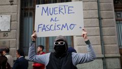 Una persona sostiene un cartel antifascista en un acto por 53 aniversario del golpe de Pinochet en Chile.