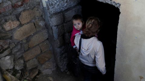 Una mujer y su hijo se refugian en el stano de su vivienda para protegerse de los ataques entre armenios y azerbaiyanos en Nagorno Karabaj